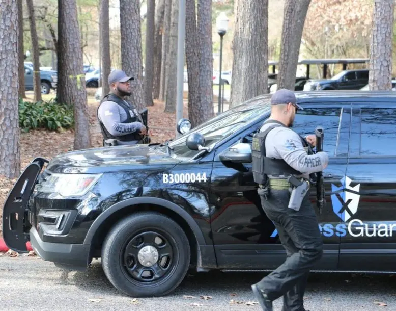 XpressGuards officers with a marked patrol vehicle